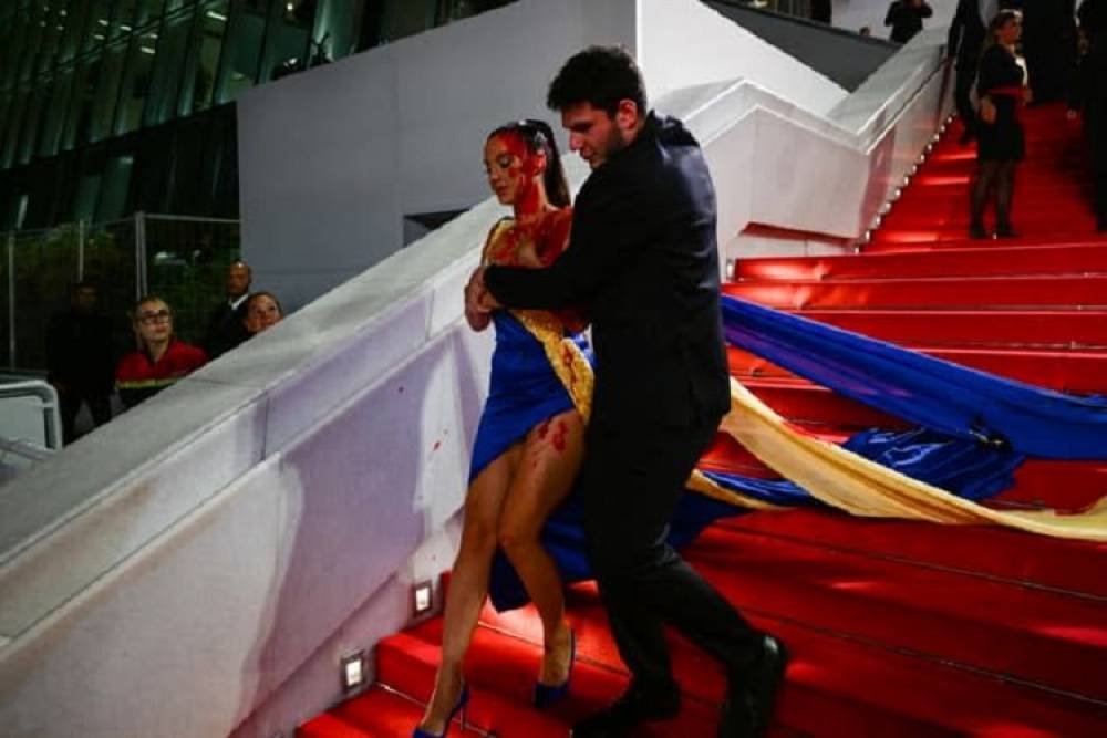 Cannes: une femme vêtue aux couleurs de l'Ukraine se recouvre de faux sang sur le tapis rouge